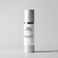 Skincare bottle labeled 'Skin Revealing Coconut & Honey Aloe Cleanser' on a light gray background