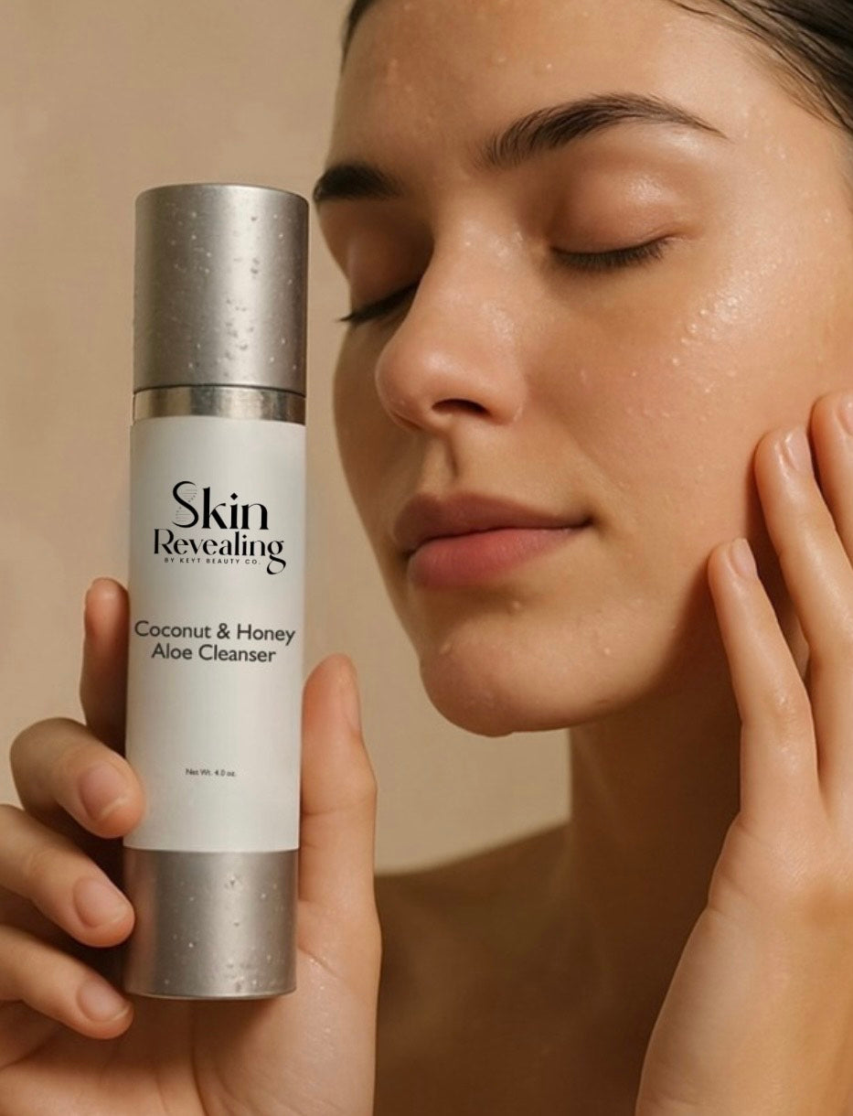 Woman holding a bottle of 'Skin Revealing' coconut & honey aloe cleanser against a neutral background